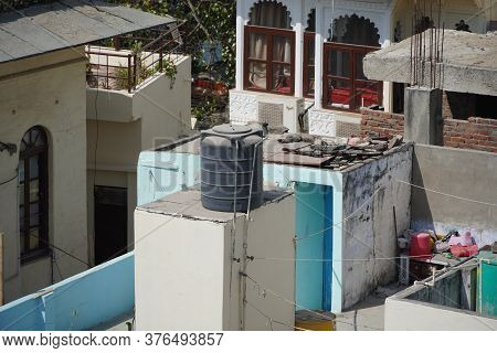 Black Water Tanks Of Industrial Building On Roof Top Or Deck Of An Old Residential Building In A Rur