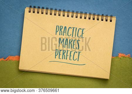 practice makes perfect - a motivational slogan in a spiral sketchbook against abstract paper landscape, education and training concept