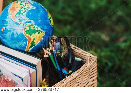 Back To School - School Equipment, Books And Globe With Ukrainian Signature In The Basket. Soft Focu