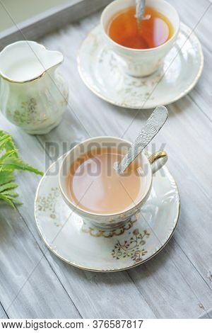 Traditional Five O'clock English Tea In An Elegant China Set. Two Cups Of Tea And Milk On A Wooden V
