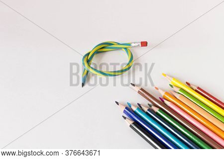 Flexible Pencil And A Set Of Colored Pencils On A Light Background. Selective Focus