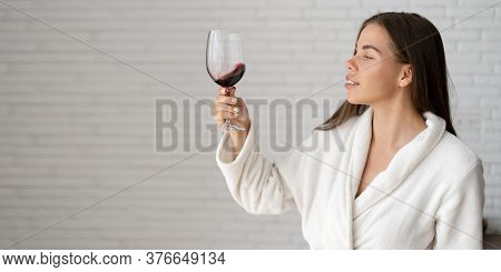 A Young Caucasian Woman Is Relaxing In A Hotel Room. Stands On The Background Of A Bulun Brick Wall.