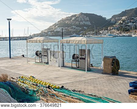 Midday At Empty Gas Station Without Customer. Fishing Net In Foreground. Gas Station In Sea  Fishing