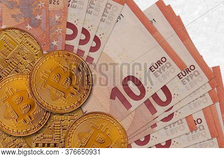 10 Euro Bills And Golden Bitcoins. Cryptocurrency Investment Concept. Crypto Mining Or Trading