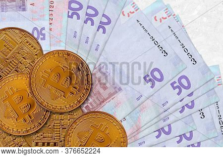 50 Ukrainian Hryvnias Bills And Golden Bitcoins. Cryptocurrency Investment Concept. Crypto Mining Or