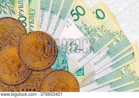 50 Belorussian Rubles Bills And Golden Bitcoins. Cryptocurrency Investment Concept. Crypto Mining Or