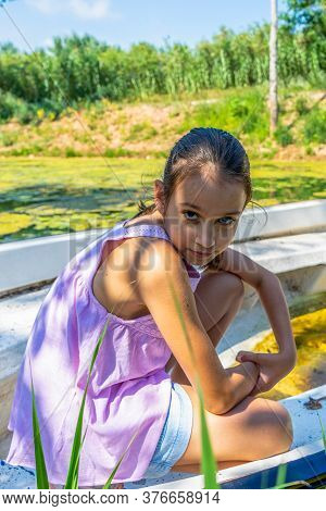 Beautiful Little Girl With Her Hair Up And Dressed In Pastel Colors Posing Fun Riding On A White Boa