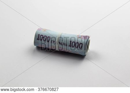 A Roll Of Ukrainian Money. Banknotes Of Ukraine Against White Background.five Thousand Hryvnia With