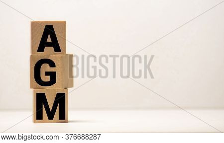 Agm Annual General Meeting Acronym On Wooden Cubes On Blue Backround. Business Concept.