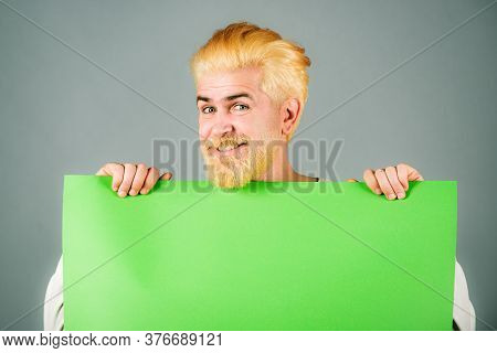 Portrait Of Funny Man Showing Blank Signboard With Copyspace Area For Slogan Or Text. Young Funny Ma
