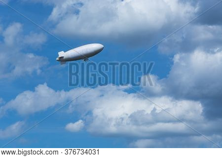Airship, Zeppelin Against Blue Sky With Dark Clouds.