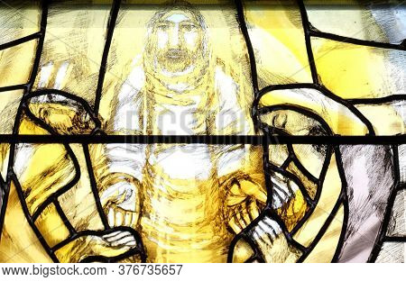 PIFLAS, GERMANY - JUNE 07, 2015: God begins salvation in this world through His Son Jesus Christ, detail of stained glass window by Sieger Koder in St. John church in Piflas, Germany