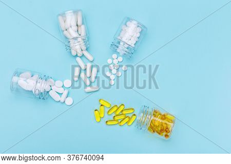 Four Packages With Various White Pills And Capcules On A White Background. Health Concept. Copy Spac