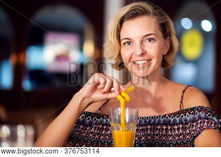 A Worker Measuring Temperature Of Woman Visitior Inside  Of The Cafe. Life During Coronavirus Time