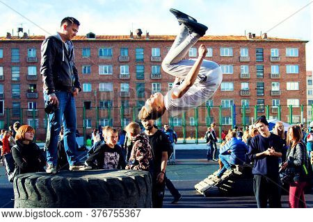 Norilsk, Russia - August, 28, 2016: Young Teenager Jumps And Does Somersaults. Parkour On The Street