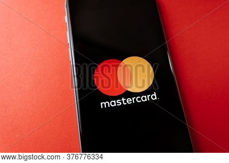 Mastercard Logo On The Smartphone Screen, On Red Background. High Quality Photo