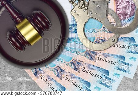 50 Sri Lankan Rupees Bills And Judge Hammer With Police Handcuffs On Court Desk. Concept Of Judicial