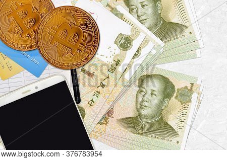 1 Chinese Yuan Bills And Golden Bitcoins With Smartphone And Credit Cards. Cryptocurrency Investment