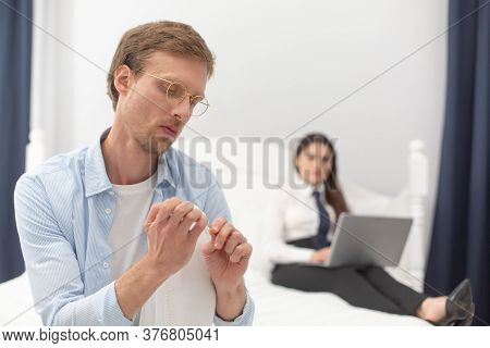 Househusband Polishing His Nails. Man Acting Feminine By Polishing His Nails While His Wife Is Worki