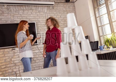 Business People Having Fun At The Office, Playing Office Games While On A Break, Knocking Down A Pyr