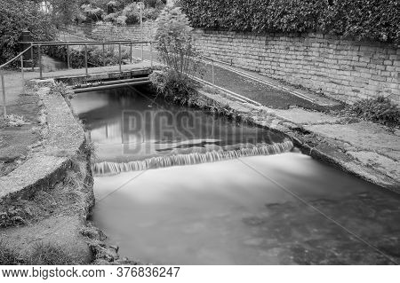 Long Exposure Of A Watefall On The River Lim Walkway At Lyme Regis In Dorset.