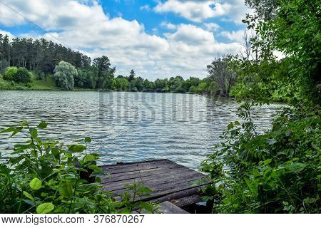 Forest Lake With A Wooden Pier In The Village Of Uhroidy (sumy Region, Ukraine). Beautiful Natural L