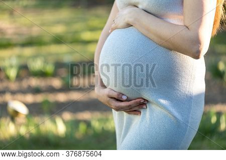 Beautiful Pregnant Woman Relaxing Outside In The Park
