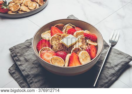 Trendy Home Breakfast With Tiny Cereal Pancakes With Piece Of Butter And Fresh Strawberries In The B