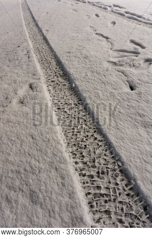 Tread Marks On Fresh Snow. Track From Car Tire. Road Covered With A Thin Layer Of Snow. Human Footpr