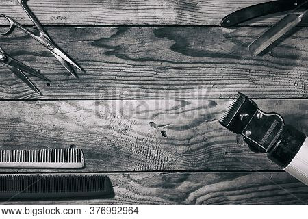 Scissors, Combs, Razors, And A Clipper On A Wooden Background. Black And White Photo. Copy Space. Be