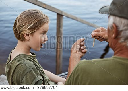 Little Boy Fishing With His Dad, Being Astonished Because Of Tangled Line On Fishing Rod, Family Pos