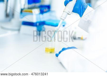 Pipetting A Chemical Sample Into Research Glass Flasks