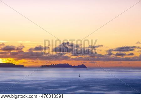 A Small Sailboat In Front Of Deserta Island, Near Madeira, Portugal. Beautiful Sunset Over The Ocean