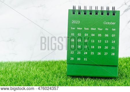 Green October 2023 Monthly Desk Calendar For 2023 Year On Grass.