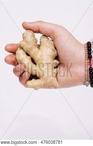 Close Up Of A Ginger Root Being Held In Hand And Against A White Background.