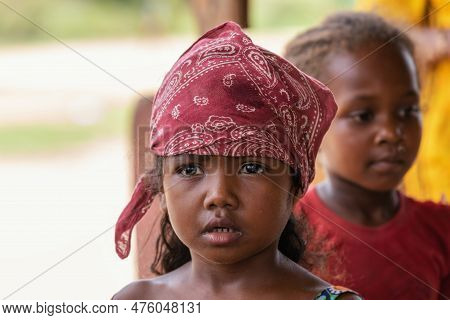 Bekopaka - Antsalova, Madagascar - November 6, 2022: Little Cute Malagasy Girl With A Scarf On Her H