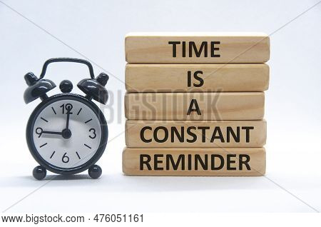 Time Is A Constant Reminder Text On Wooden Blocks With Alarm Clock On White Background.