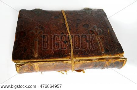 Old Weathered Book With Leather Cover And Loose Spine. It Is Held Together By A Leather Cord. The Ba