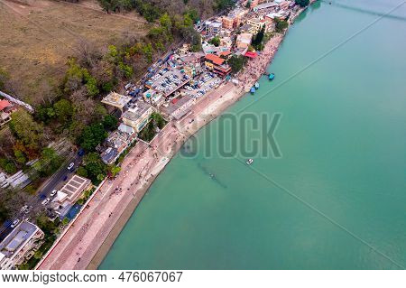 Aerial Drone Shot Of Blue Water Of River Ganga Stretching Into Distance With Steps Stairs On The Gha
