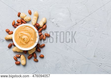 Bowl Of Peanut Butter And Peanuts On Table Background. Top View With Copy Space. Creamy Peanut Pasta