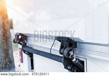 Close-up Detail View Of Modern White Delivery Truck Tail Door With Hydraulic Lift Mechanism On City 