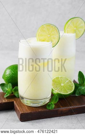 Brazilian Lemonade, Refreshing Creamy Lemonade Or Limeade With Lime Slices And Mint On Grey Backgrou