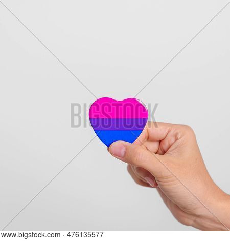 Bisexuality Celebrate Day And Lgbt Pride Month,  Lgbtq+ Or Lgbtqia+ Concept. Hand Holding Purple, Pi