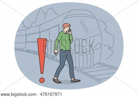 Young Man Talking On Phone Crossing Tracks While Train Is Approaching. Careless Guy Speak On Cellpho