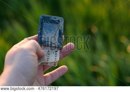 E-waste Recycling - Old, Damaged Cell Phone In Hand. Copy Space For Text.