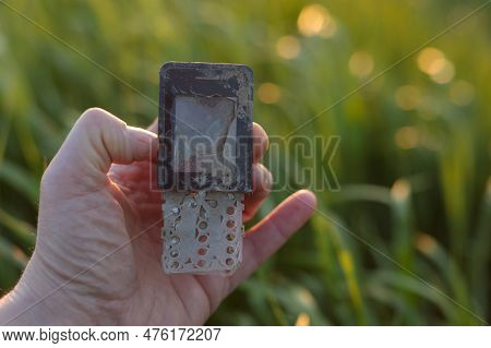 Hand Holding Aged Mobile Phone - E-waste Recycling Issue Concept. Copy Space For Text.