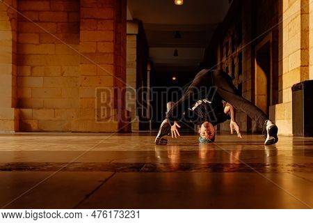 Boy In His Teens Break Dancing On A Tiled Floor In The Arcades Of A Historic Building. Street Dancer