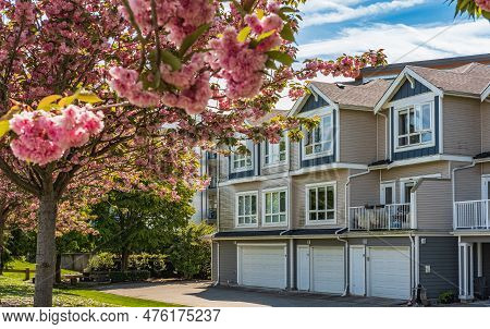 Nice Neighborhood On A Sunny Day. Row Of Garage Doors At Parking Area For Townhouses.garage Door Wit