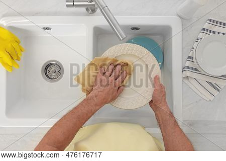 Man Wiping Plate Above Sink, Top View