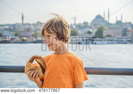Boy In Istanbul Having Breakfast With Simit And A Glass Of Turkish Tea. Glass Of Turkish Tea And Bag